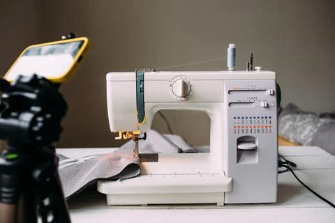 Shooting video of the sewing process, workshop on clothing design on smartphone Stock Photos