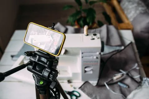 Shooting video of the sewing process, workshop on clothing design on smartphone Фото