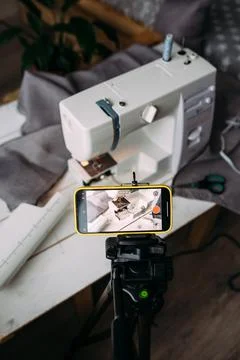 Shooting video of the sewing process, workshop on clothing design on smartphone Stock Photos