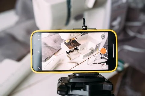 Shooting video of the sewing process, workshop on clothing design on smartphone Фото