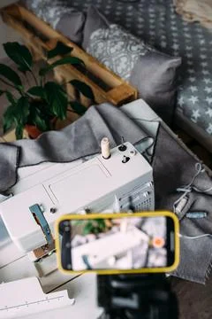Shooting video of the sewing process, workshop on clothing design on smartphone Stock Photos