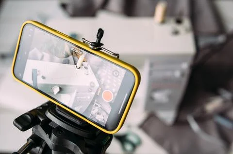 Shooting video of the sewing process, workshop on clothing design on smartphone Stockfoto's