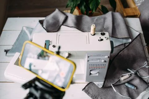 Shooting video of the sewing process, workshop on clothing design on smartphone Фото