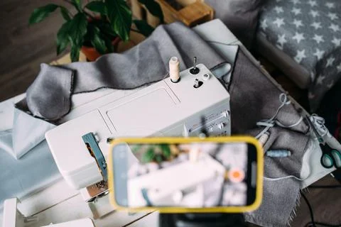 Shooting video of the sewing process, workshop on clothing design on smartphone Fotos Stock