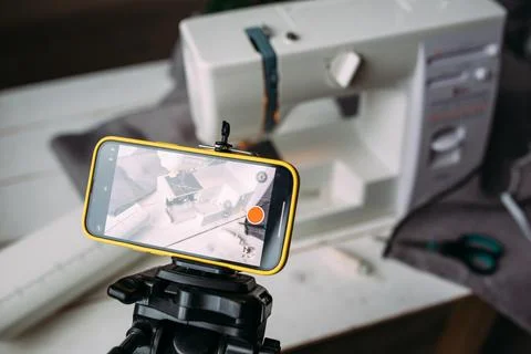 Shooting video of the sewing process, workshop on clothing design on smartphone Photos