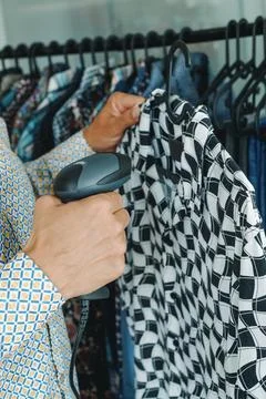 Shop assistant in a clothes shop using a barcode scanner Foto stock