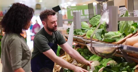 Shop assistant in grocery store helping shoppers Stock Footage 73511368