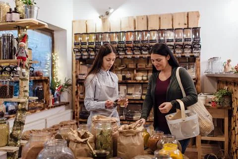 Shop assistant helping customer in packaging free shop. Stock Photos
