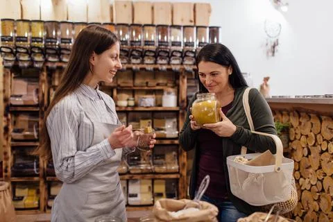 Shop assistant helping customer in packaging free shop. Stock Photos