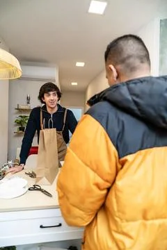 Shop assistant serving customer with brown paper bag Stock Photos