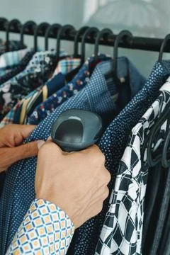 Shop assistant uses a barcode scanner in a clothes shop Foto stock