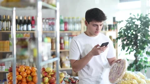 In shop guy scans QR code and take reading on pizza with prosciutto filling Stock Footage 308952669