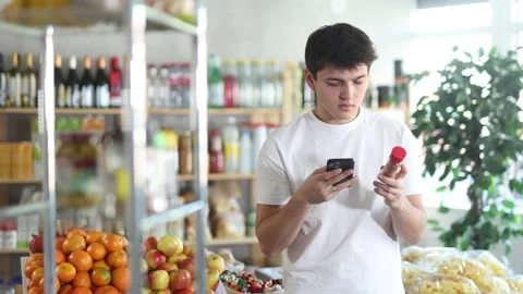 In shop guy scans QR code and take reading chopped red ground pepper using phone Stock-Footage 325028069