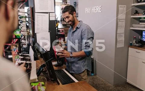 Shop owner at the billing counter making sales Stock Photos
