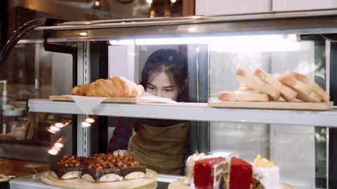 Shop owner is checking bakery, open candy cabinet bend down count number tr.. Stock Footage 245099816
