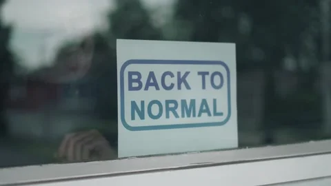 Shop Owner Placing a BACK TO NORMAL Sign on its Window After Pandemic 스톡 동영상 156413728