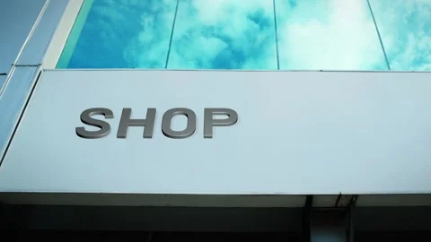 Shop Sign on Modern Building with Cloud Reflection on Windows Glass Stock Footage 303568039