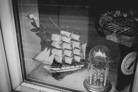 In a shop window there is a model of a sailing ship and an old clock Stock Photos