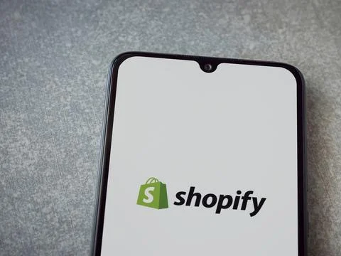 Shopify app launch screen on smartphone on ceramic stone background Foto stock