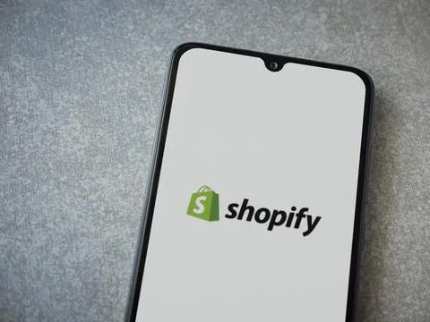 Shopify app launch screen on smartphone on ceramic stone background Foto stock