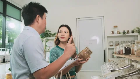 A shopkeeper and customer in refill store, zero-waste, and plastic-free grocery. Stock Footage 213749864