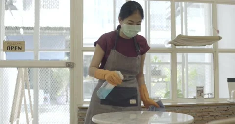 Shopkeeper cleaning table preparing to open shop Stock Footage 133641553