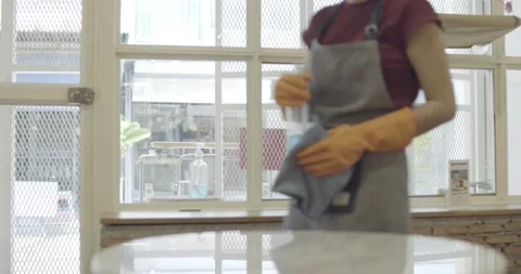 Shopkeeper cleaning table preparing to open shop Stock Footage 133641560