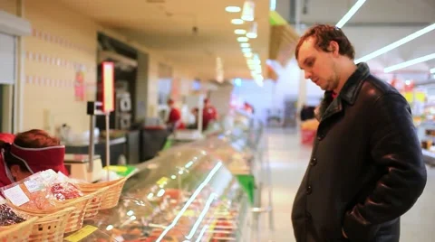 Shopkeeper serving customer in a grocery store In sausages and meat products. HD Stock Footage 47457874