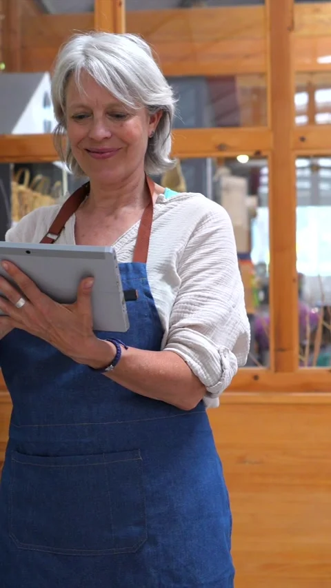 Shopkeepers using digital tablet and discussing in store Stock Footage 311304719