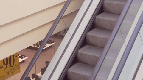 Shopper On Escalator In Shopping Mall Using Mobile Phone Stock Footage 73364419