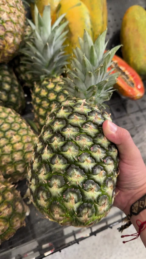 Shopper Hand Lifting Ripe Pineapple from Market Bin Stock Footage 337911456