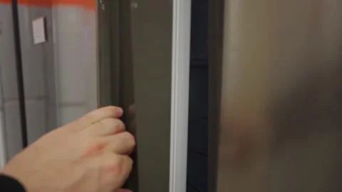 A shopper interacts with a refrigerator in a retail store Stock Footage 297651827