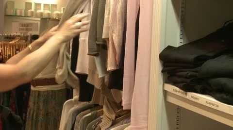Shopper looking through clothes on a clothes rack Stock Footage 8981377