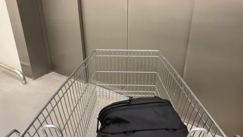 Shopper pushing empty shopping cart in shopping mall elevator Stock Footage 150695738