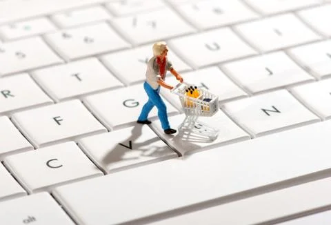 Shopper pushing a trolley over a computer keyboard Stock Photos