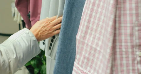 Shopper Running Her Hand Over Clothing Displayed On Rails Stock Footage 330462522