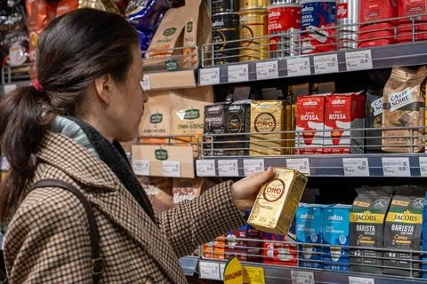 Shopper selects coffee for purchase at store. Minsk, Belarus - april 1, 2025 Foto stock