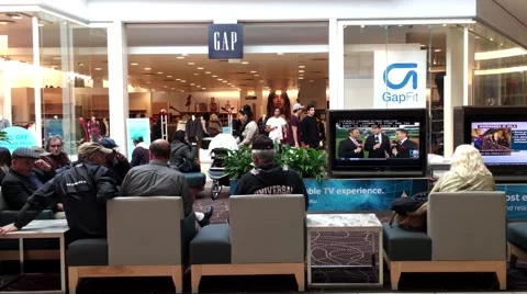 Shopper sitting rest area and watching TV inside Coquitlam Center shopping mall Stockbeeldmateriaal 59508968