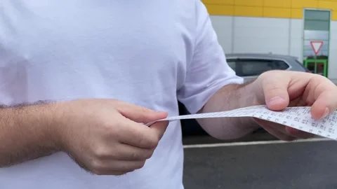 A shopper standing in the parking lot, checking the receipt to ensure he wa.. Stock Footage 252022069