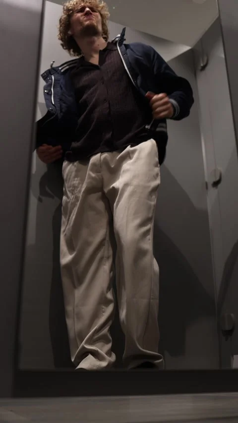 Shopper tries on a jacket but dislikes how it fits in the fitting room Stock Footage 344855368