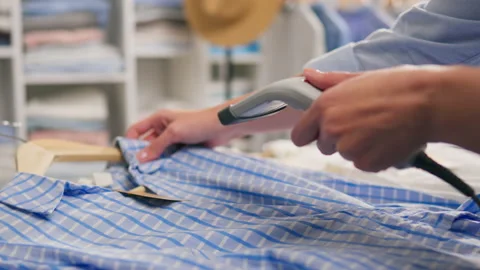 A shopper uses an RFID reader to scan a tag on a new piece of clothing in a Vídeo Stock 235218126