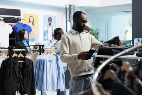 Shopper using smartphone while shopping 写真素材