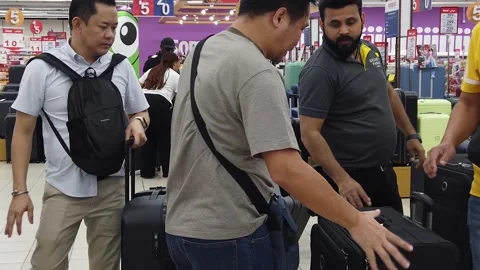 Shoppers browsing and selecting suitcases in the luggage section of Carrefour Video stock 312560417