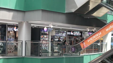 Shoppers down Escalator to Big Camera in Thailand Mall Vídeo Stock 241583048