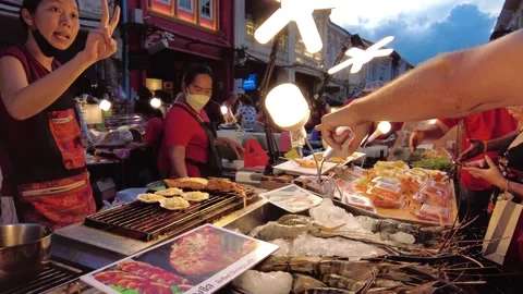 Shoppers haggle with the chef over the amount of fried shrimp Stock Footage 207993203
