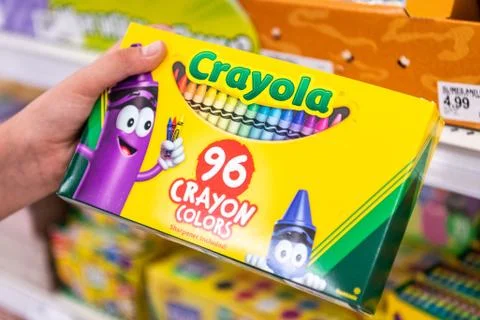 Shoppers hand holding a box of Crayola brans 96 crayon colors Stock Photos