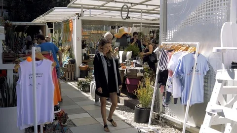 Shoppers look at clothes in an outdoor market in Venice, Los Angeles, California Stock Footage