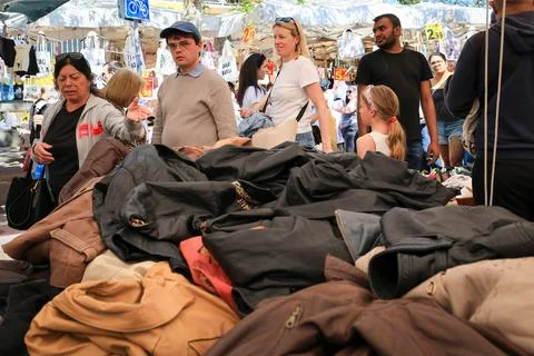 Shoppers looking through leather jackets at a Porta Portese market stall. Stock-Fotos