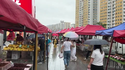 Shoppers Move Through a Busy Rainy Market in Dandong China Stock Footage 340176070