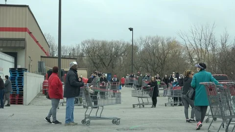 Shoppers practicing physical distancing while lining up outside Costco store Stock Footage 129417152
